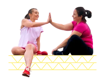 Two women sitting and high fiving each other